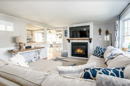 West Dennis Cape Cod vacation rental - Living room w/ fireplace opens to kitchen and dining area.