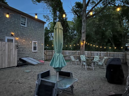 Yarmouth Cape Cod vacation rental - Fenced-in backyard with a fire pit, grill and lounge chairs
