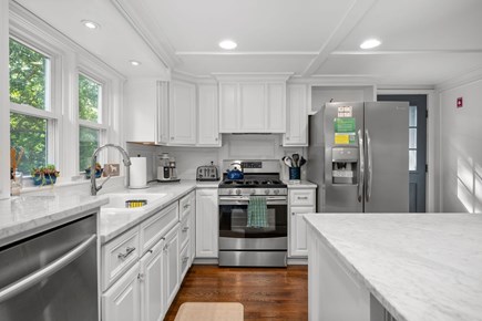 Harwich Cape Cod vacation rental - Large kitchen with stainless steel appliances, granite countertops and access to the deck through the depicted door
