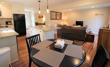 Harwich Cape Cod vacation rental - Dining space overlooking kitchen with island and TV space