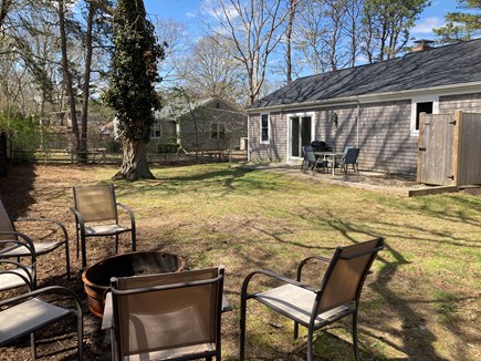 West Yarmouth Cape Cod vacation rental - Fenced backyard with patio and fire pit.