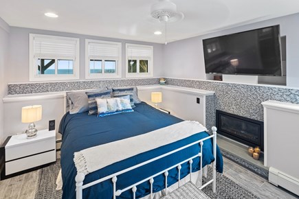 Plymouth, Ocean's Edge Oasis MA vacation rental - Primary bedroom on boasts a mounted television and gas fireplace.
