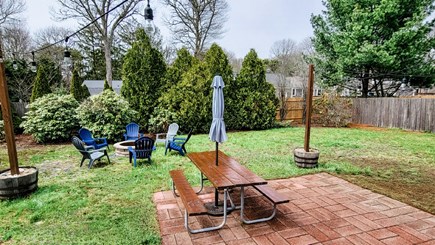 West Yarmouth Cape Cod vacation rental - Fenced in backyard with table, firepit and bucket sand boxes