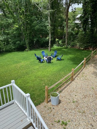 Dennis Port Cape Cod vacation rental - Fire pit and Adirondack chairs in the half acre spacious backyard