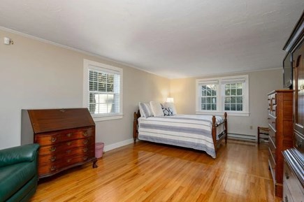 West Harwich Cape Cod vacation rental - Spacious primary bedroom with stately furniture and king size bed