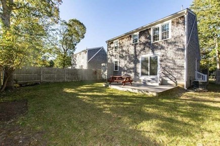 South Yarmouth Cape Cod vacation rental - Fenced in backyard w/ shower, firepit, grill, & patio furniture