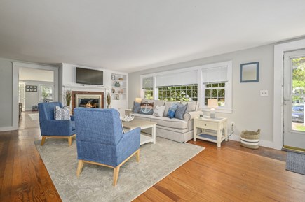 Harwich Port Cape Cod vacation rental - Living room with fireplace, TV and entrance to the home.
