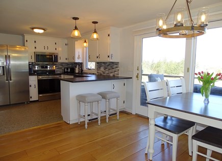 East Dennis Cape Cod vacation rental - Dining area and kitchen with breakfast bar, slider to deck