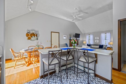 Harwich Cape Cod vacation rental - Kitchen island with seating and open concept dining area.