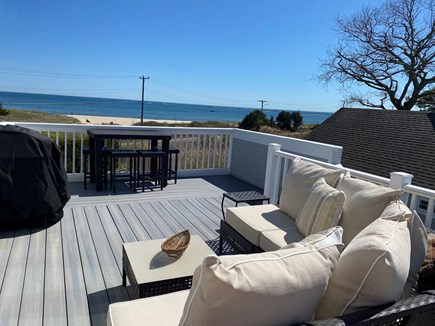 Hyannis Cape Cod vacation rental - Ocean view from outdoor lounge area with dining table and grill.