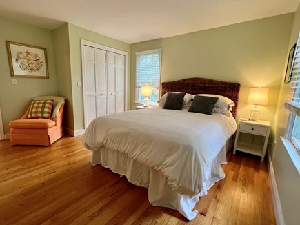 Brewster Cape Cod vacation rental - Bedroom 2 has a queen bed with a rattan headboard and side chair.