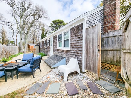 Dennisport Cape Cod vacation rental - Back patio with seating, firepit, and outdoor shower.