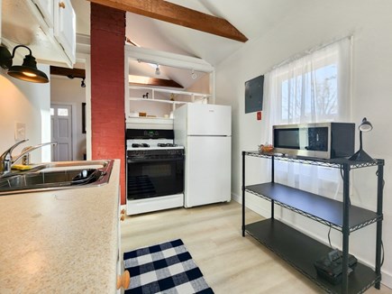 Harwich Cape Cod vacation rental - View of kitchen with sink, stove, fridge, and microwave.