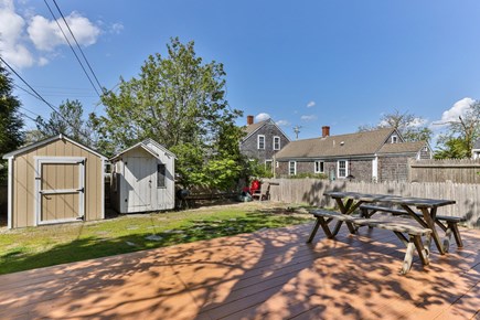 Harwich, Bank Street Beach Cottage Cape Cod vacation rental - Fence lined outdoor space with picnic table, chairs & grill.