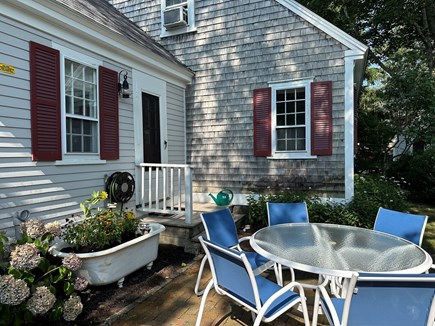 Wellfleet Cape Cod vacation rental - Shady back patio with table, 6 chairs, and propane grill.