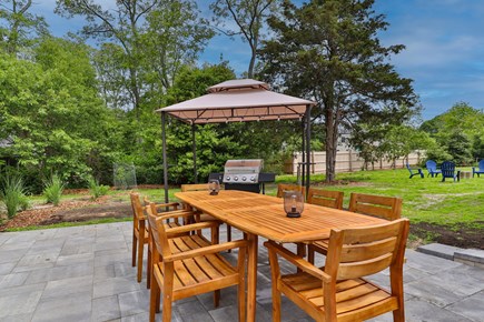 Eastham Cape Cod vacation rental - Outdoor Dining Area with eight chairs around a grill w/ a cabana
