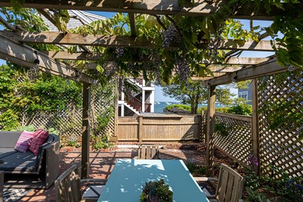 Provincetown, Martin House 157 Cape Cod vacation rental - Outdoor Dining under Wisteria with Ocean View
