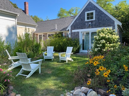 North Truro Cape Cod vacation rental - Sitting area near flowers and kitchen and sliding door entrance.