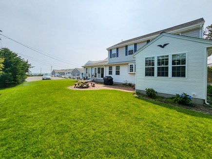Dennis Cape Cod vacation rental - Spacious side lawn with outdoor living area and view of beach