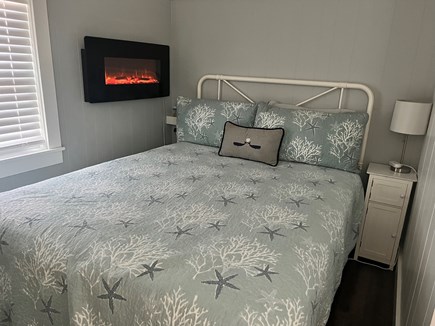Dennis Port Cape Cod vacation rental - Queen bed, hanging electric fireplace, charging ports + dressers.