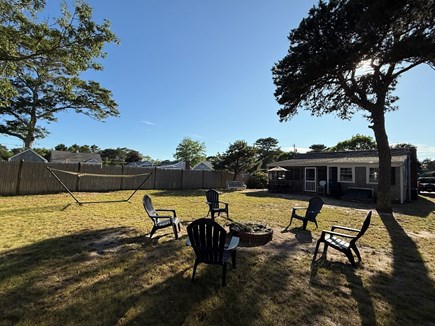 Dennis Port Cape Cod vacation rental - Spacious backyard with fire pit, hammock, and backyard games