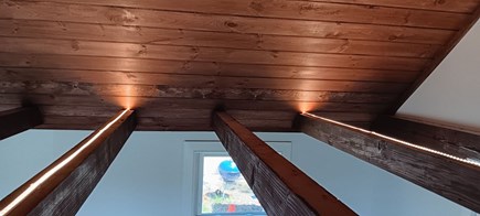 Eastham Cape Cod vacation rental - Adding indirect lighting to top of beams in living room.