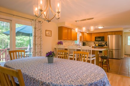Mashpee Cape Cod vacation rental - Open concept dining and kitchen with a slider to the backyard.