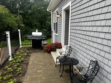 Cataumet Cape Cod vacation rental - Path from driveway, with bistro set and gas grill and entry.