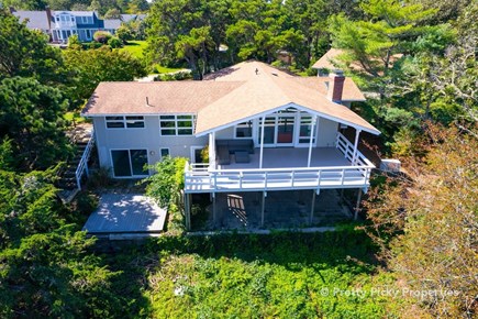 Orleans Cape Cod vacation rental - Backside of the house featuring a large deck. Dining table now included.