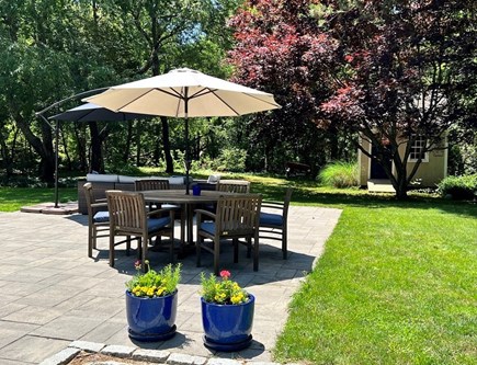 Dennis Cape Cod vacation rental - Outdoor dining and lounge area on stone patio. Private backyard.