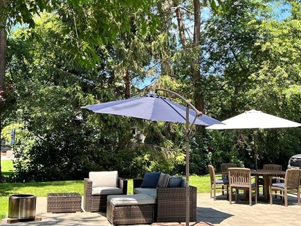 Dennis Cape Cod vacation rental - Shaded outdoor living room with firepit.