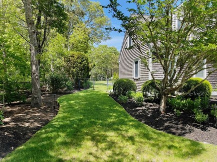 Harwich Port Cape Cod vacation rental - View of the path around the left side of the home toward the backyard