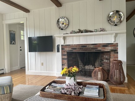 Chatham Cape Cod vacation rental - TV on a swivel mount and fireplace.  Front entrance on the left.
