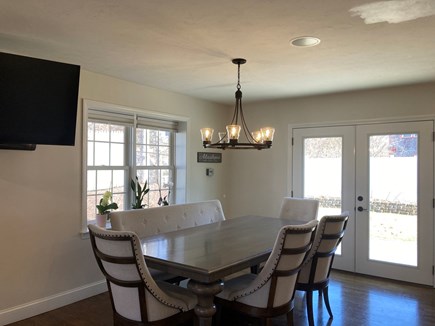 Mashpee Manor Pool House Cape Cod vacation rental - Dining area off of living room with TV open to gourmet kitchen.