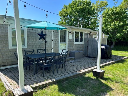 Dennis Port Cape Cod vacation rental - Back patio with outdoor shower, grill, table for 6, & cafe lights