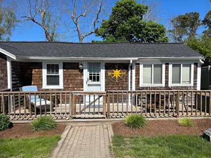 Dennis Port Cape Cod vacation rental - Front of the cottage with table for 4 and lounge chair.