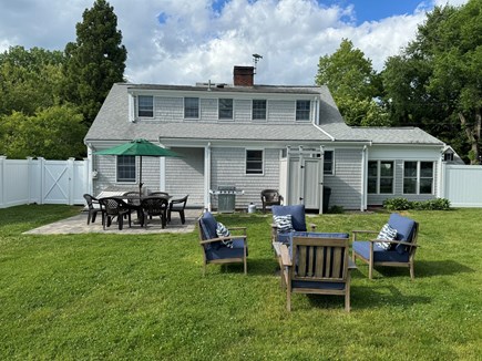 Falmouth Cape Cod vacation rental - Backyard with outdoor shower, grill, patio set and firepit area