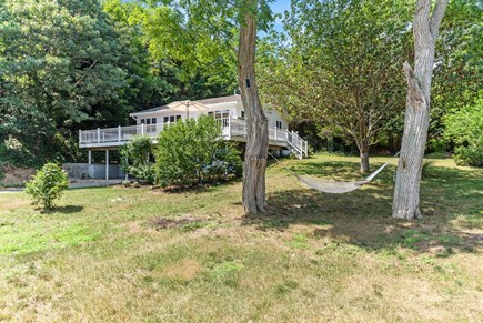 Wellfleet Cape Cod vacation rental - Large yard with hammock, view of large deck beyond.