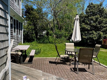 East Dennis Cape Cod vacation rental - Back patio, Umbrella with 8 chairs, picnic table, gas grill.