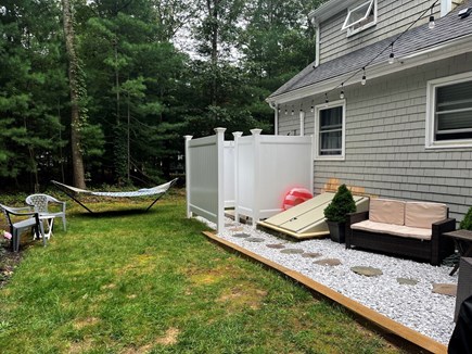 Falmouth Cape Cod vacation rental - View from backyard to outdoor shower, more seating + hammock