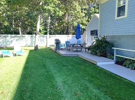 South Yarmouth Cape Cod vacation rental - Fenced back yard with deck, seating area and grill