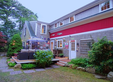 Brewster Cape Cod vacation rental - Deck with couch and dining table, showing path to outdoor shower