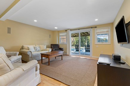 Dennis Cape Cod vacation rental - Basement with smart TV, couches and walkout to back patio/yard