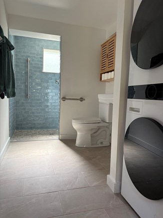 Harwich Cape Cod vacation rental - Newly renovated accessible bathroom with small washer/dryer unit.
