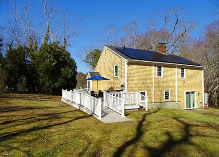 Eastham Cape Cod vacation rental - Back of house showing slider to lower level, new patio 2025