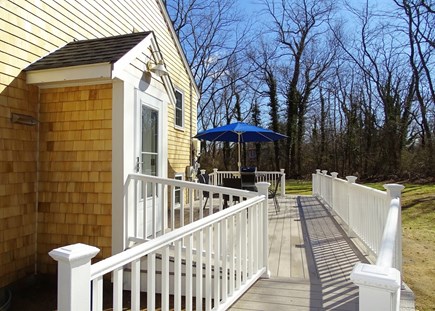 Eastham Cape Cod vacation rental - Deck area w/ dining table and gas grill, overlooking private yard