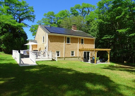 Eastham Cape Cod vacation rental - Back of house showing slider to lower level, new Pergola