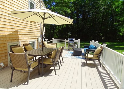 Eastham Cape Cod vacation rental - Deck area w/ dining table and gas grill, overlooking private yard