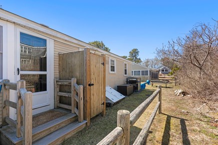 Dennis Cape Cod vacation rental - Back yard, outdoor shower, and picnic table with umbrella.