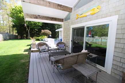 Dennis Cape Cod vacation rental - Shaded outdoor space with deck and pool in background